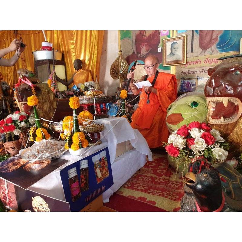 Monk performing rituals with powerful communication amulet Thailand surrounded by decorations and offerings