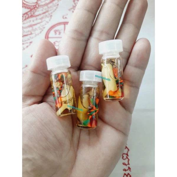 Three small vials containing powerful communication amulet Thailand on a person's palm for spiritual clarity