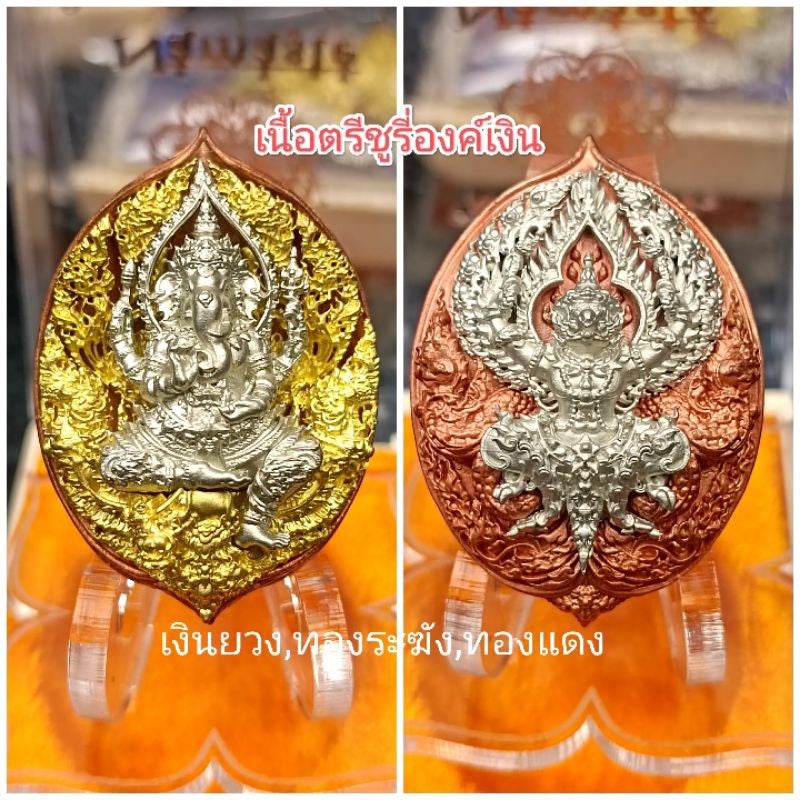 Premium Buddhist amulet for prosperity with intricate gold and copper designs displayed on a clear stand