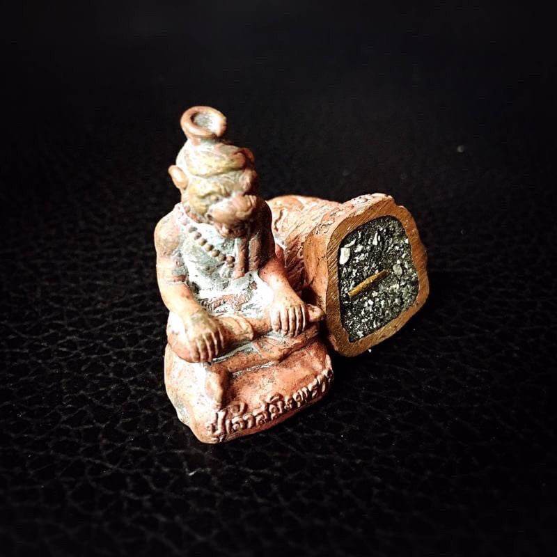 Pu Jao Saming Prai spirit talisman small figurine with intricate details on black textured surface