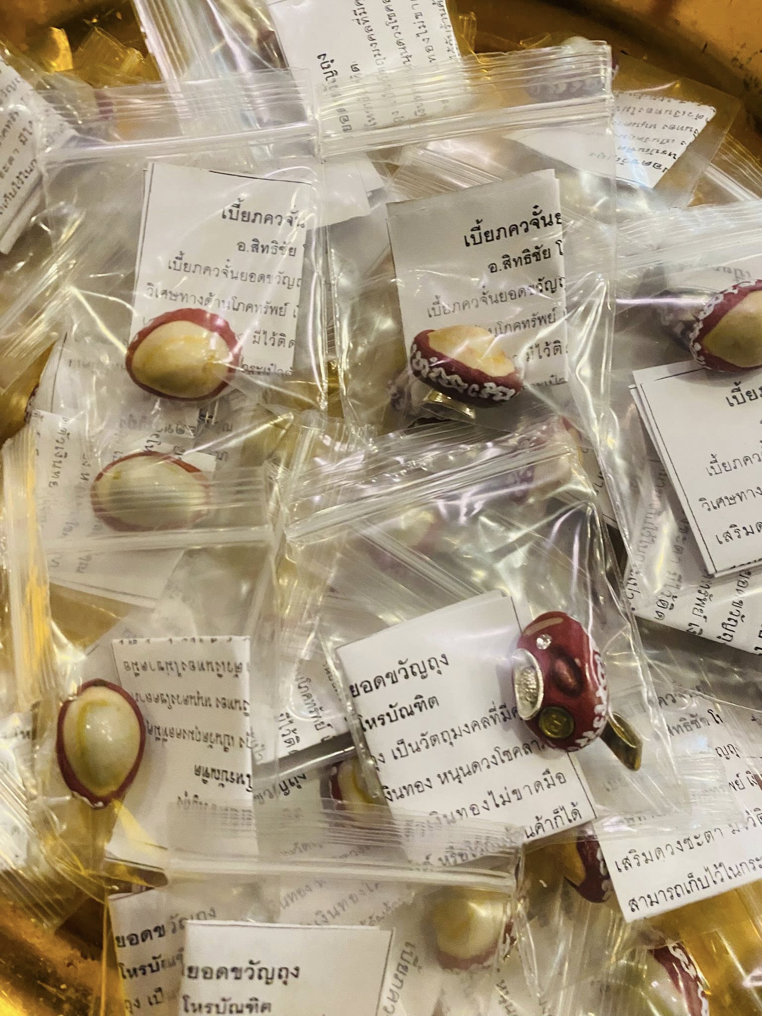 Thai Blessing Co lucky millionaire amulet for wealth small red and gold amulets in clear bags with papers