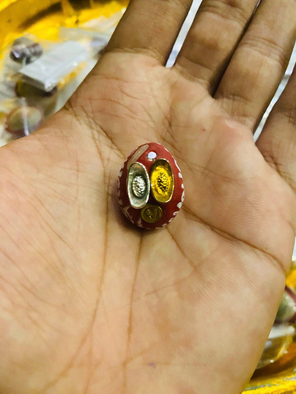 Thai Blessing Co small red amulet held in hand showing gold and silver inserts lucky millionaire amulet for wealth