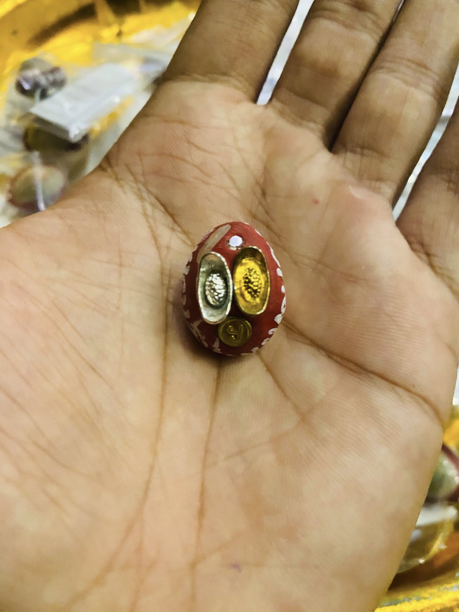 Thai Blessing Co small red amulet held in hand showing gold and silver inserts lucky millionaire amulet for wealth