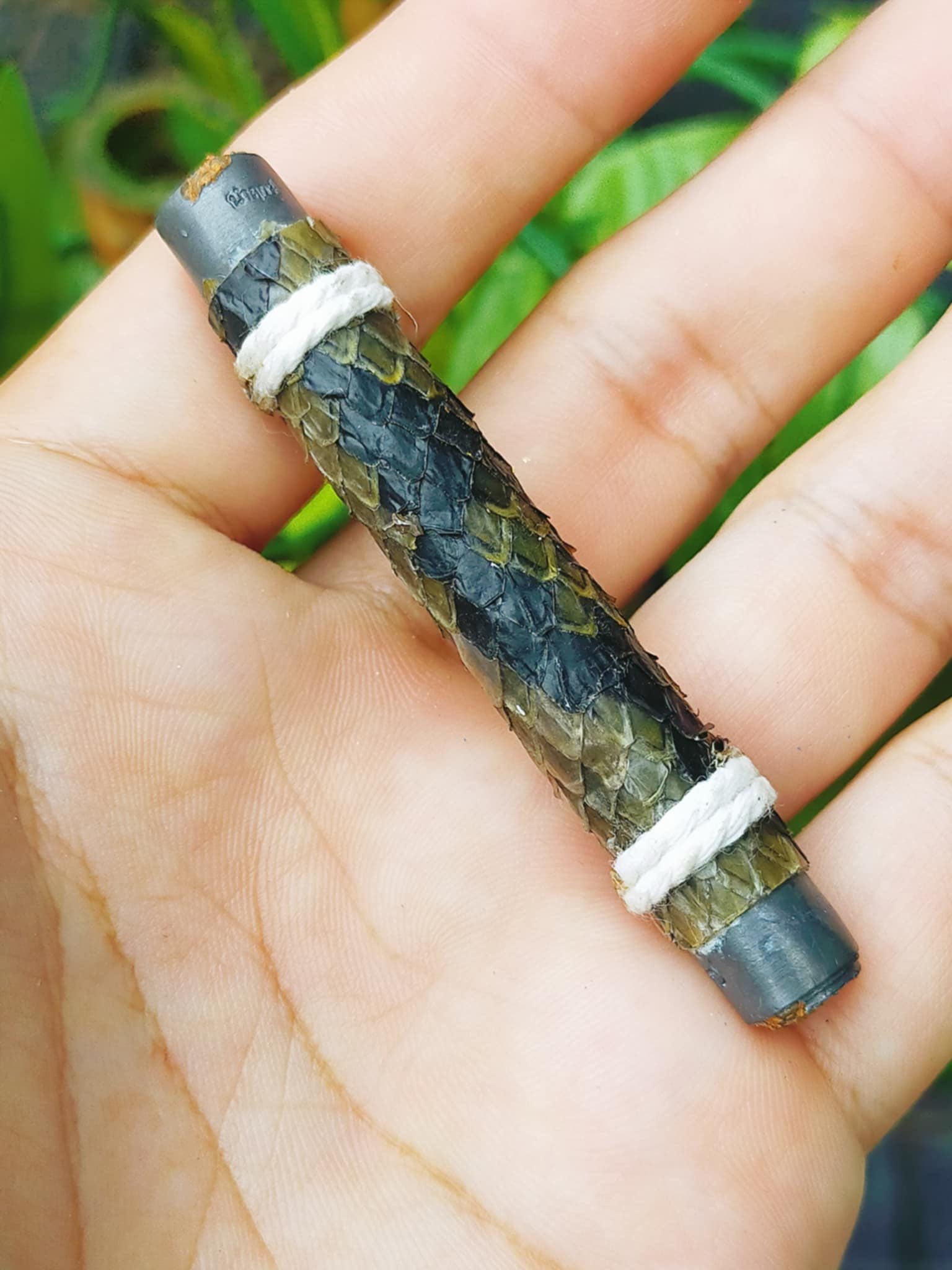 Handheld authentic Thai python skin talisman tube amulet wrapped with white cord and metal caps