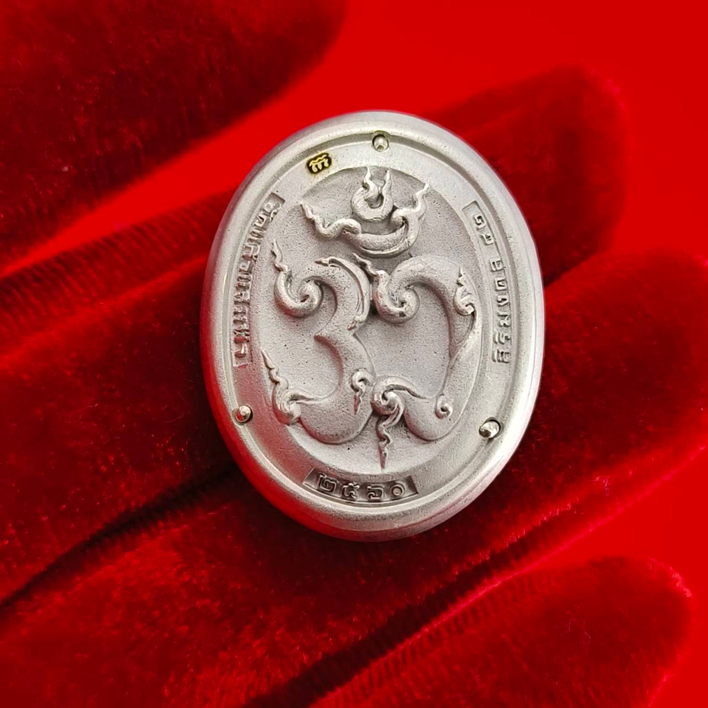 Sacred Ganesha talisman for fortune displayed on a red velvet background, showcasing detailed engravings