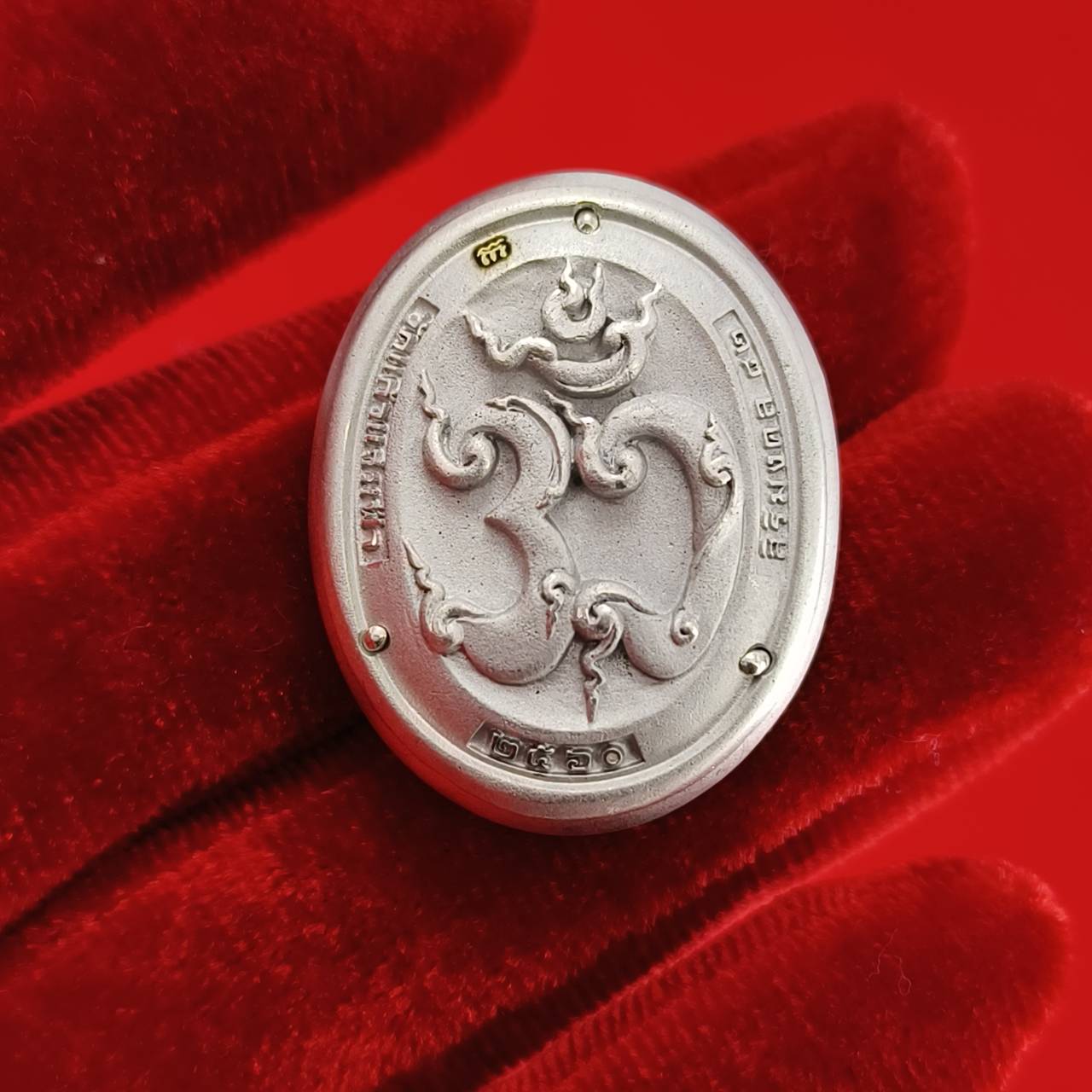 Sacred Ganesha talisman for fortune displayed on a red velvet background for spiritual decoration