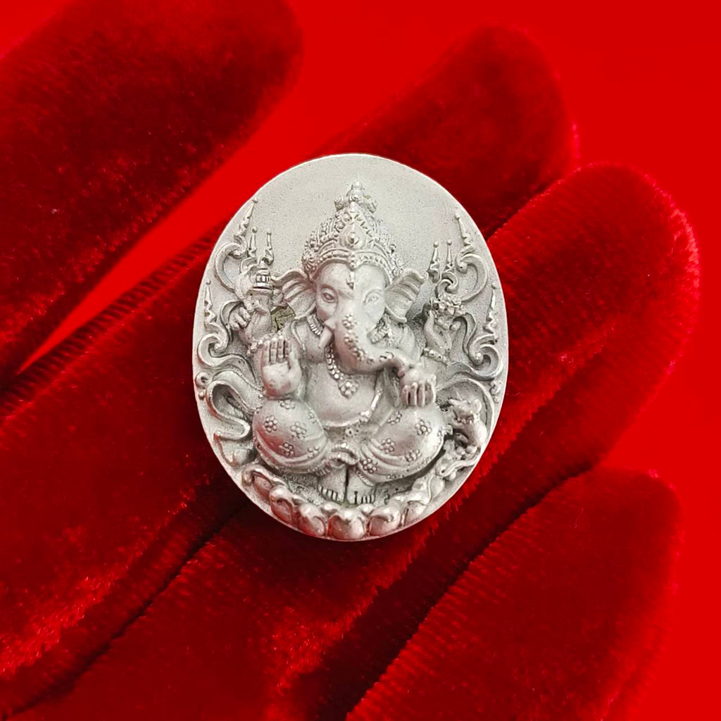 Sacred Ganesha talisman for fortune intricately designed in silver on a red background