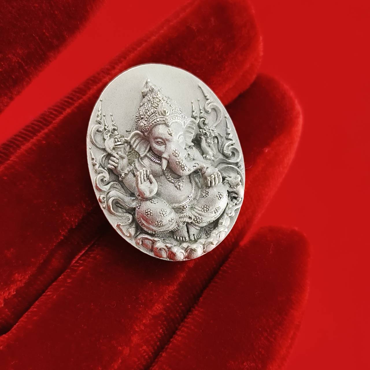 Sacred Ganesha talisman for fortune, intricately designed on a silver oval background