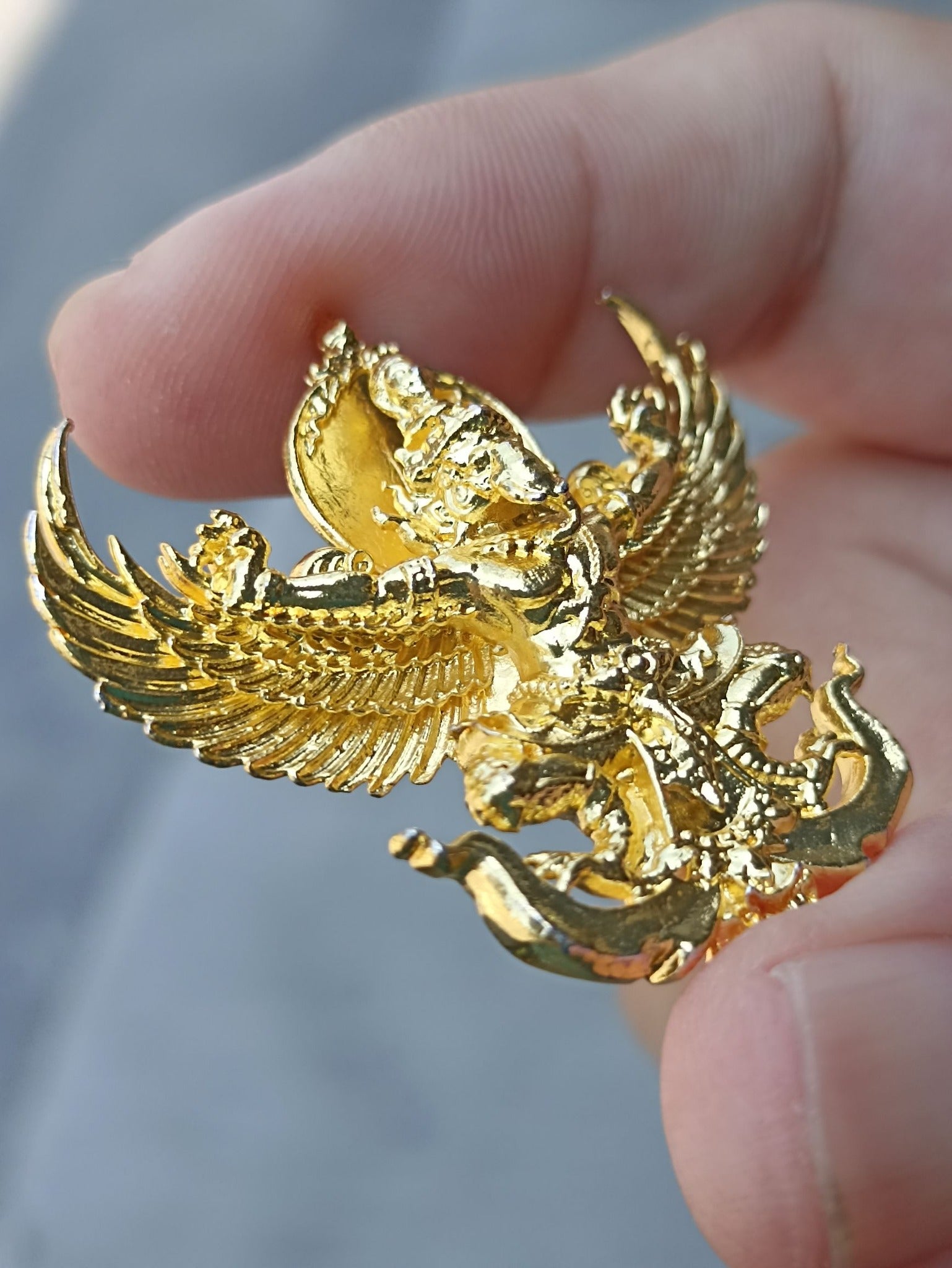Sacred Thai elephant-bird amulet in gold finish held in hand for home decoration and spiritual significance