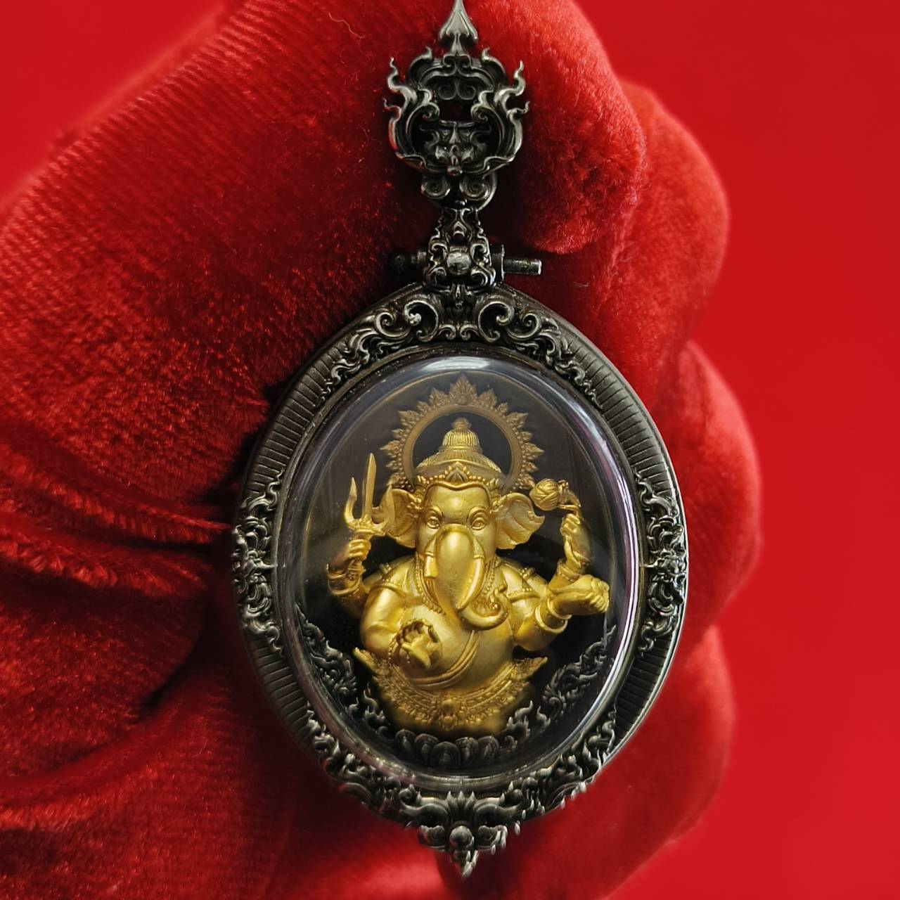 Thai Ganesh pendant white satin gold in ornate silver frame amulet held against red velvet background by Thai Blessing Co