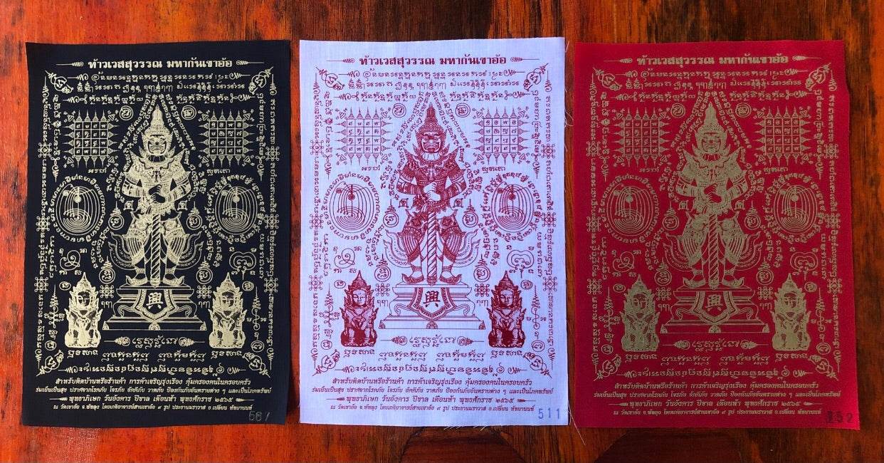 Three Phaya Wes Suwan yantra cloth amulets in black white and red showing deity and sacred script