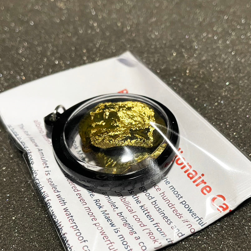 Thai wild cat placenta amulet gold leaf pendant sealed in round black waterproof case on white card