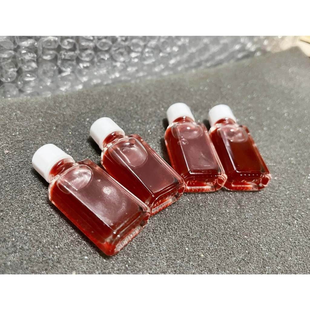 Four bottles of seduction oil for wealth and charm by Thai Blessing Co on a protective surface