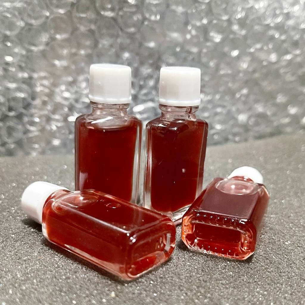 Four small bottles of seduction oil for wealth and charm, ideal for attraction and prosperity rituals