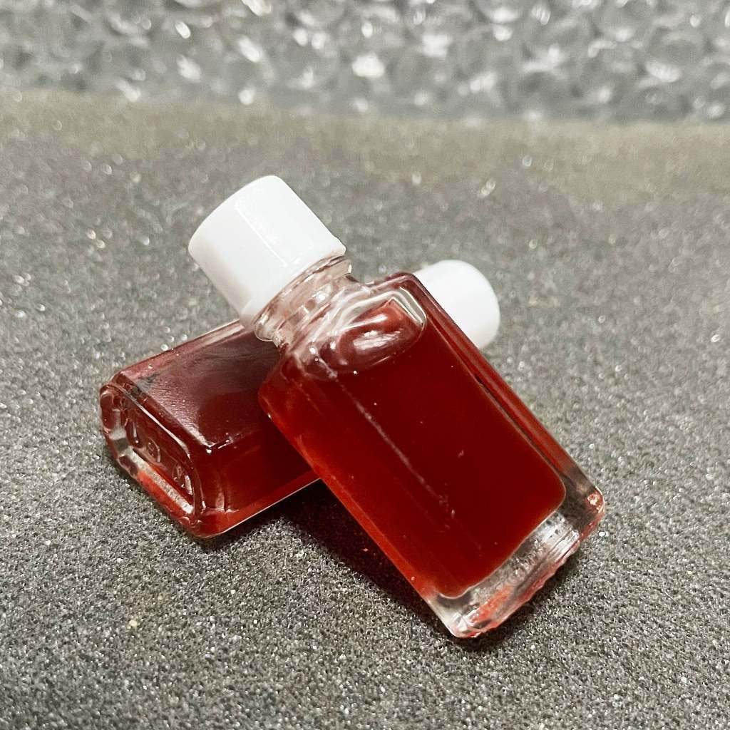 Thai Blessing Co Seduction oil for wealth and charm in small glass bottles on a textured surface