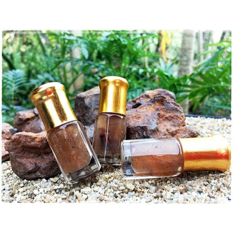 Thai Blessing Co Thai love attraction oil in small glass roll on bottles with gold caps on rocks and gravel