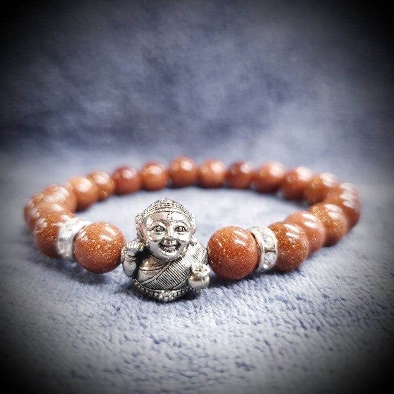 Thai prosperity bracelet for business success featuring goldstone beads and a charm of a happy figure