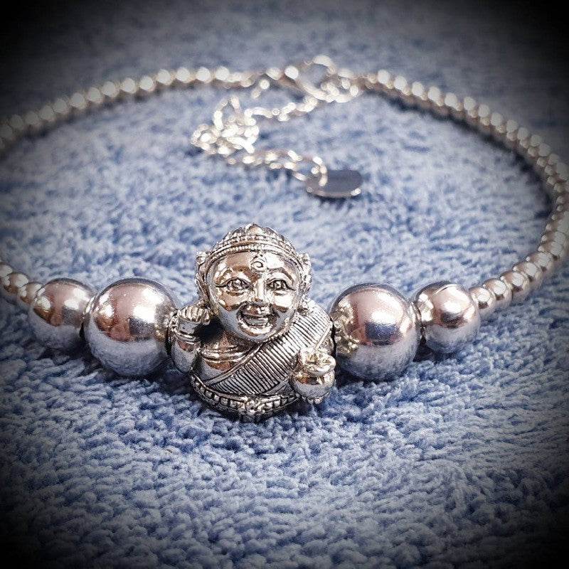 Thai prosperity bracelet for business success featuring a silver deity charm and shiny beads