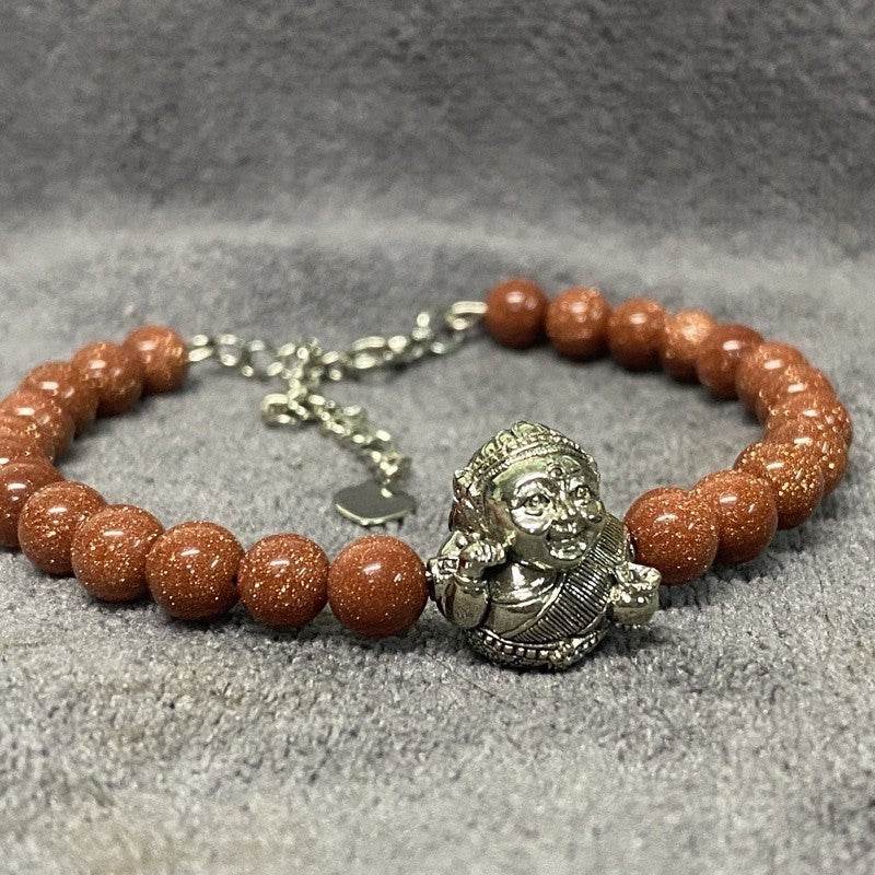 Thai prosperity bracelet for business success featuring goldstone beads and a charm of a traditional figure