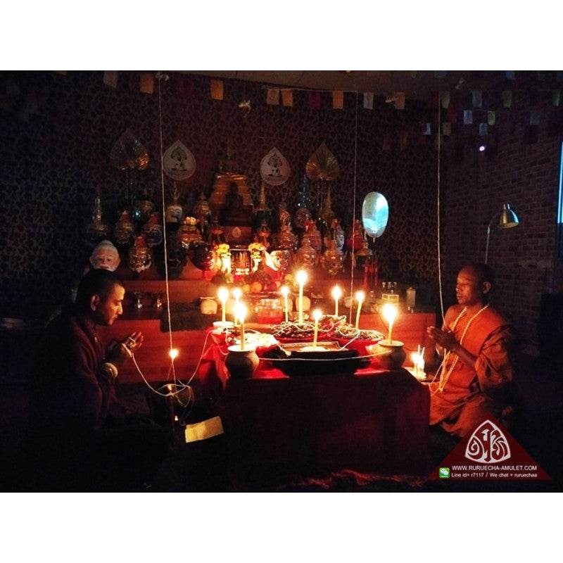 Thai love attraction oil blessing ceremony altar with candles and monks for spiritual infusion by Thai Blessing Co