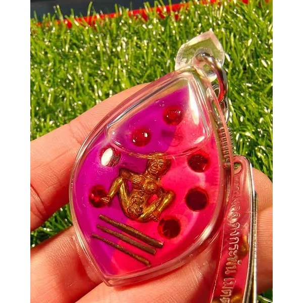 Thai golden face charm pendant with pink background and red beads inside clear protective casing