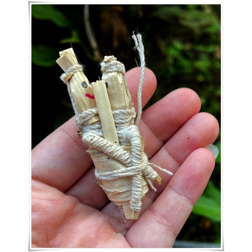 Handcrafted spiritual amulet for attraction and relationship, made from natural materials, held in a palm.