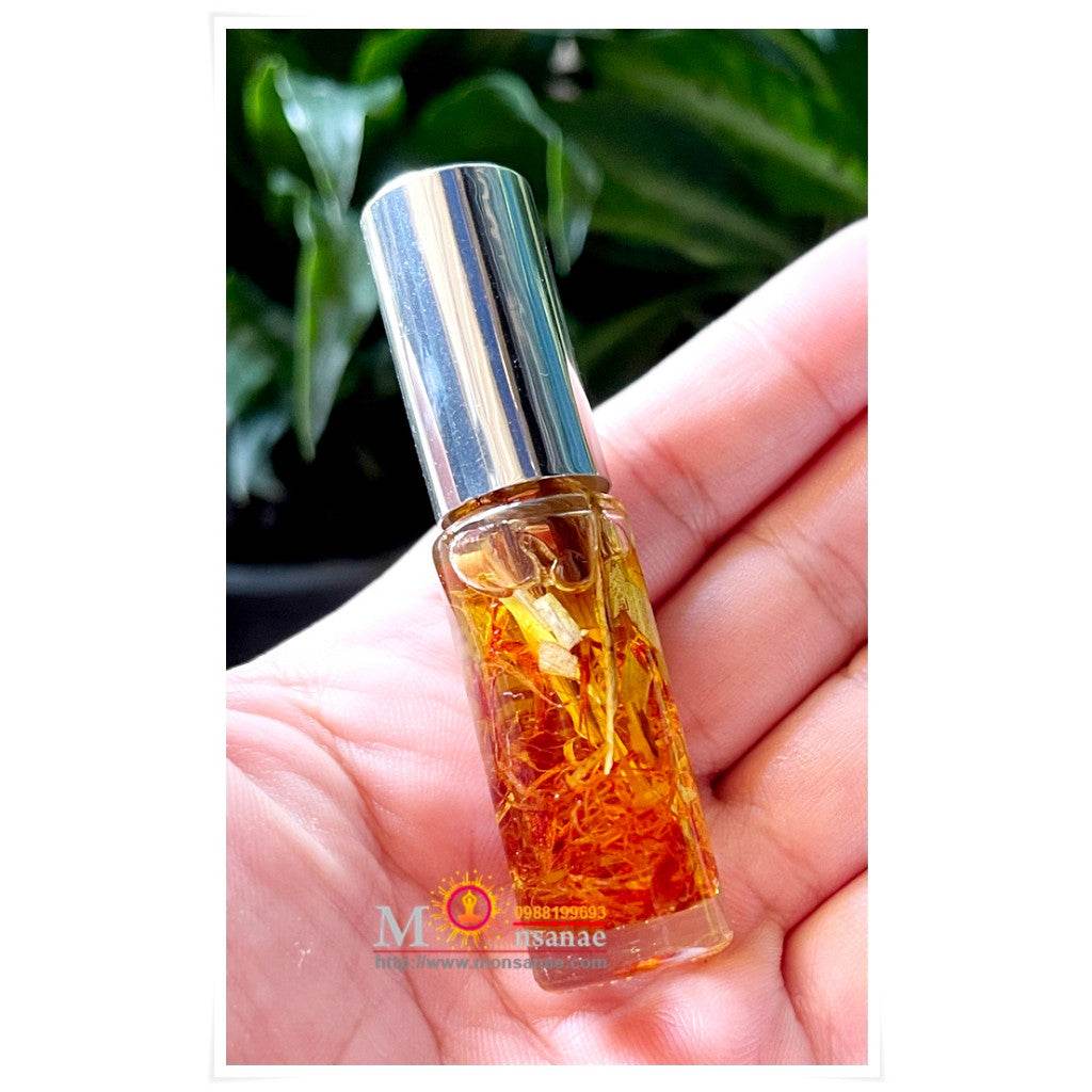 Bottle of spiritual oil for grace and attraction with natural herbs for enhancing positive energy