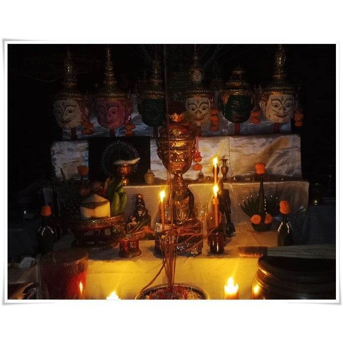 Thai Blessing Co spiritual oil for rekindling love displayed on an altar with candles and offerings
