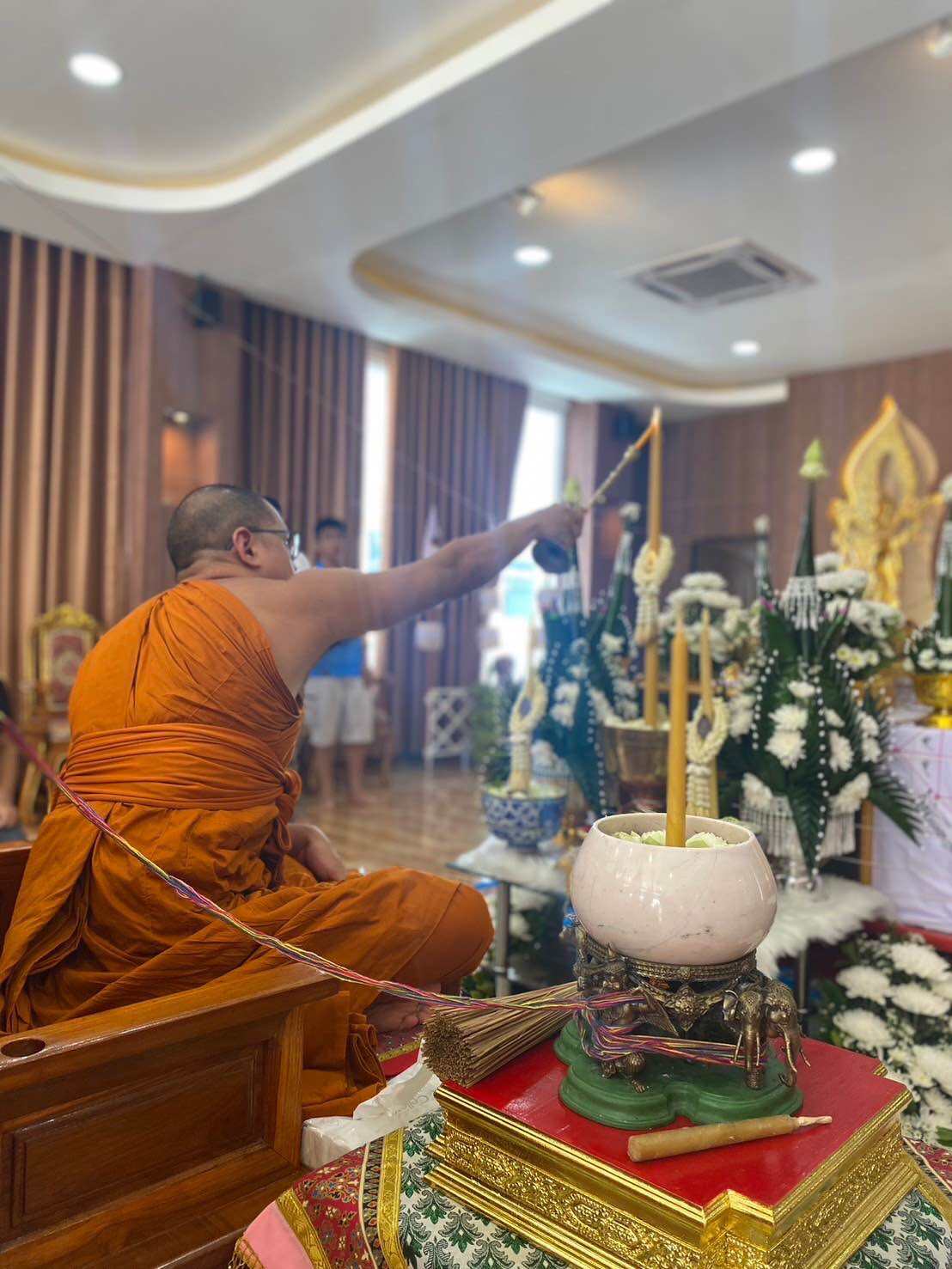 Ceremony featuring a monk consecrating the Supreme Brahma amulet by Phra Ajarn Weeraphon with ceremonial items
