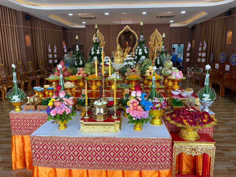 Elegant display of offerings for Supreme Brahma amulet by Phra Ajarn Weeraphon with floral arrangements and fruit