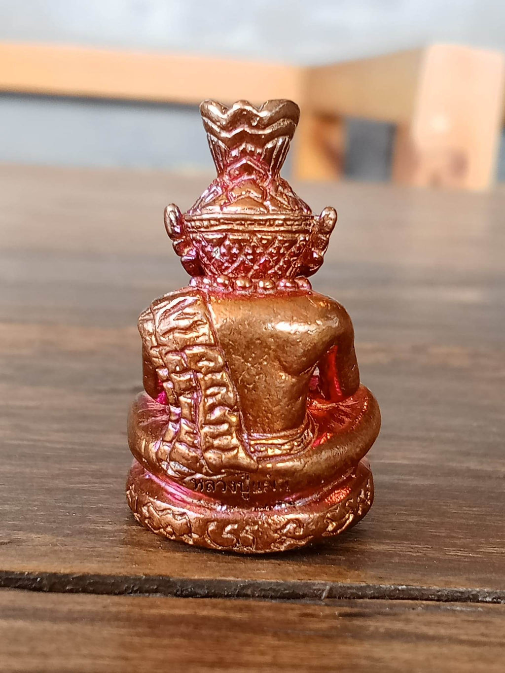 Back view of Supreme Ruesi Narot amulet, showcasing detailed craftsmanship in a gold and red finish
