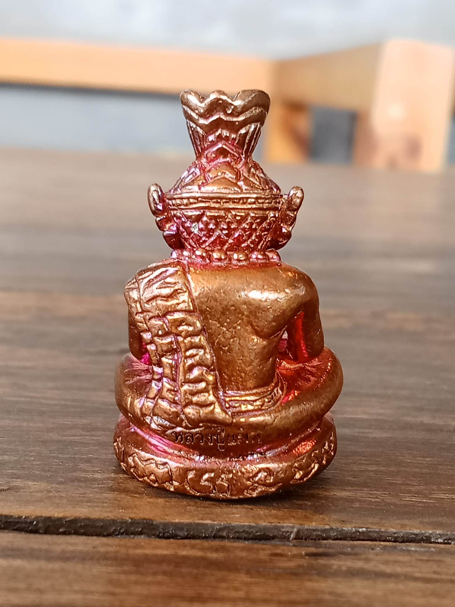 Back view of Supreme Ruesi Narot amulet, showcasing detailed craftsmanship in a gold and red finish