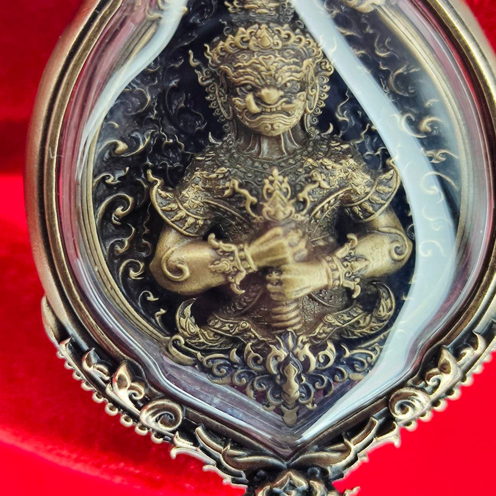 Tao Wessuwan amulet for protection with intricate gold detailing and clear casing for display