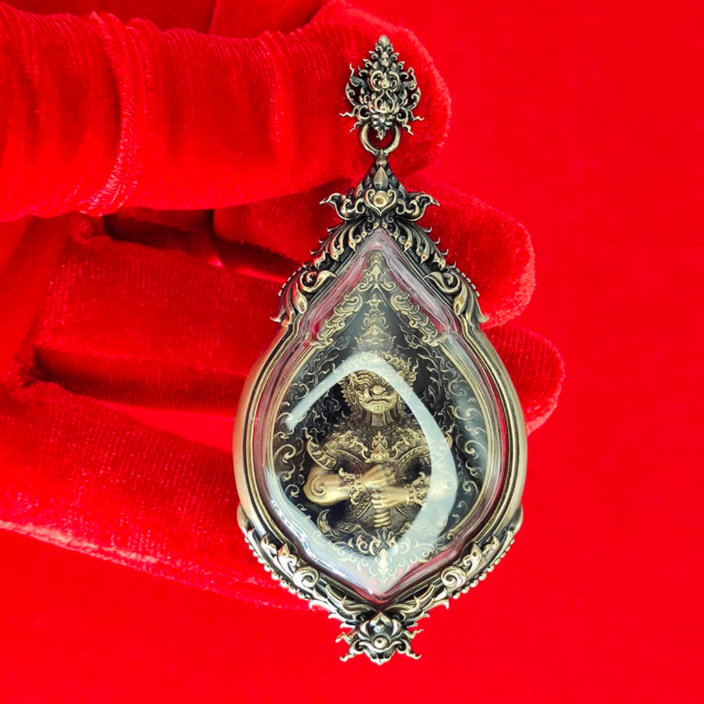 Tao Wessuwan amulet for protection in ornate silver casing with intricate design, shown against a red background