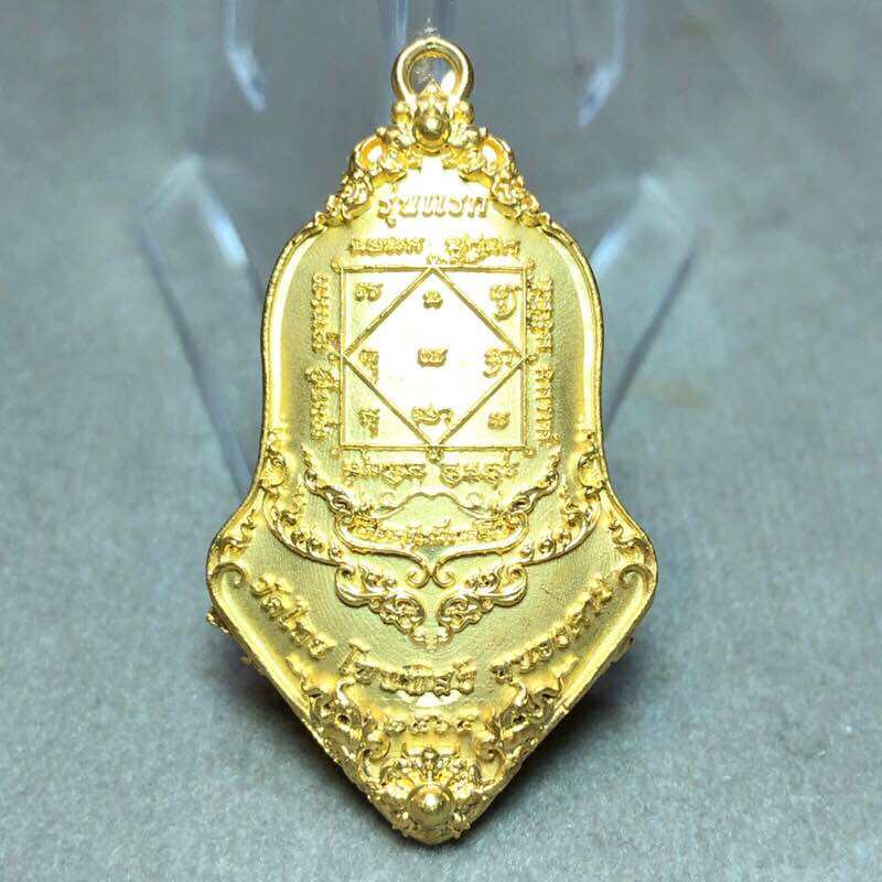 Gold Tao Wessuwan amulet for wealth featuring intricate designs and auspicious symbols