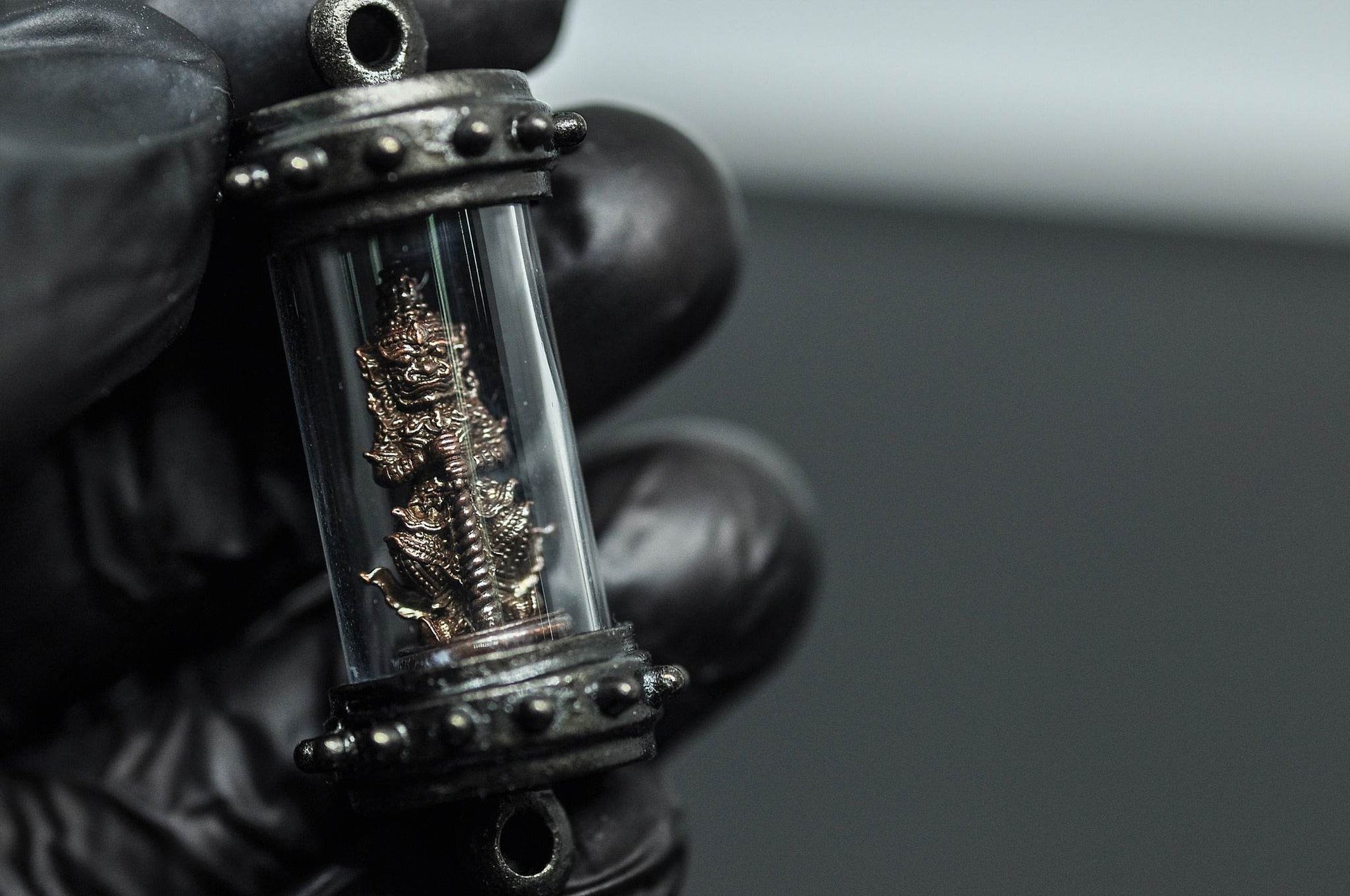 Tao Wessuwan amulet Thailand in a protective case, showcasing intricate design and craftsmanship
