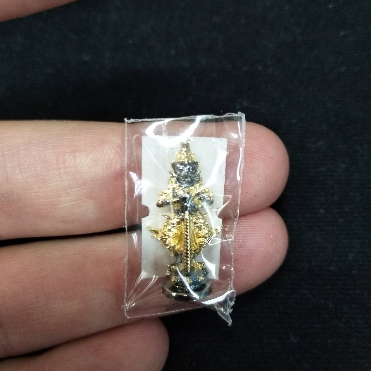 Taow Wessuwan amulet for wealth in protective packaging, featuring intricate details and vibrant colors