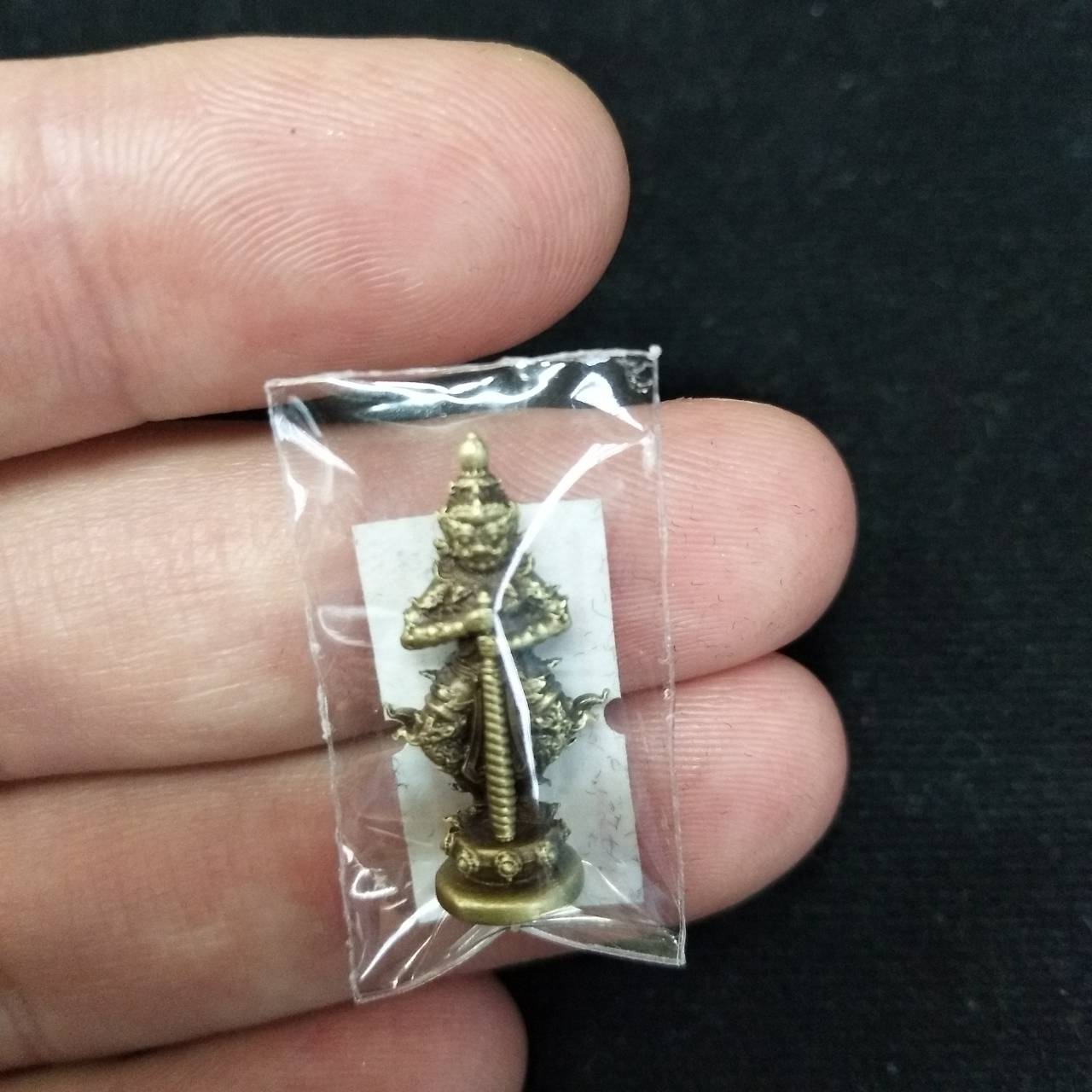 Taow Wessuwan amulet for wealth in a protective plastic casing for decorative and collectible purposes