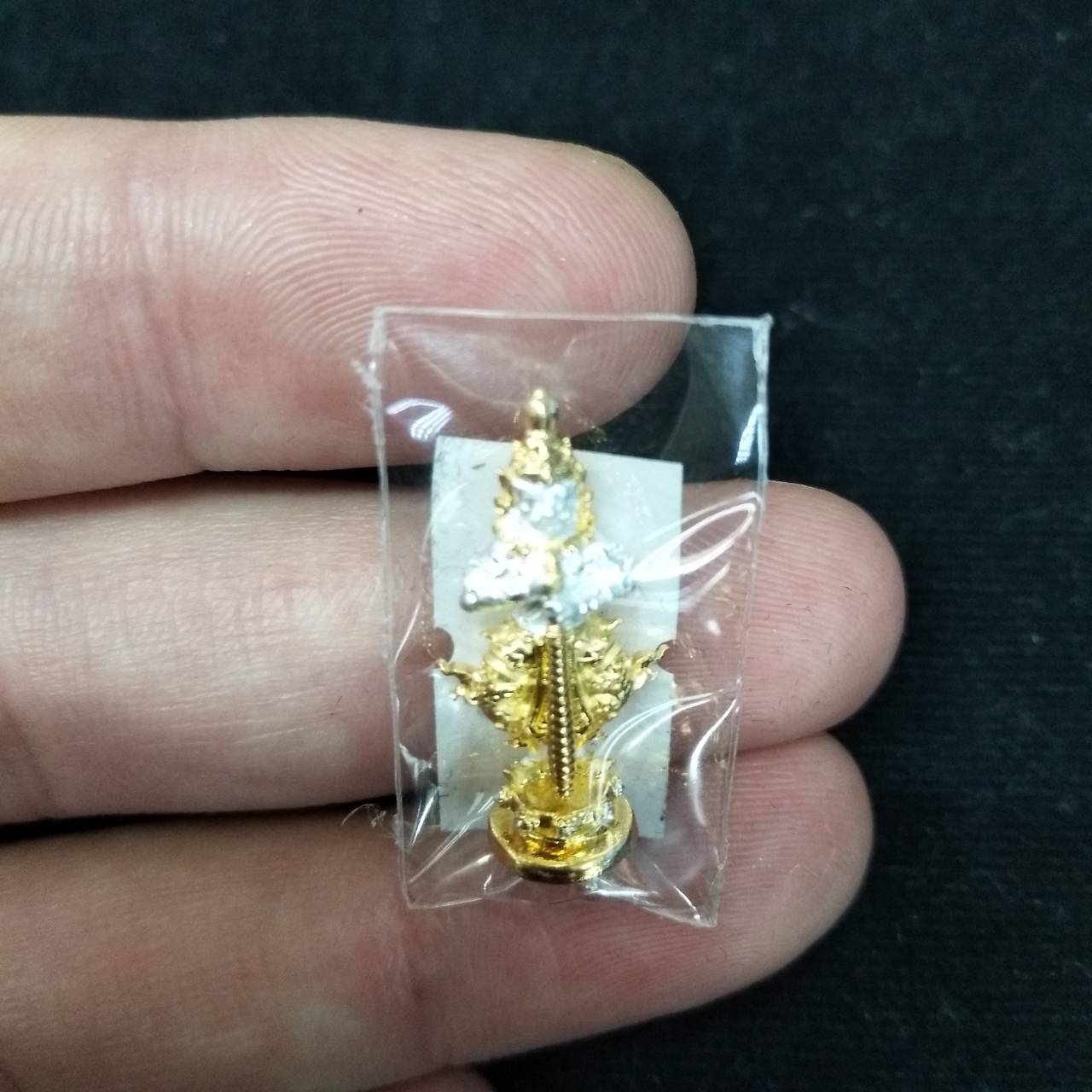 Taow Wessuwan amulet for wealth in gold finish, held in hand, ideal for attracting prosperity