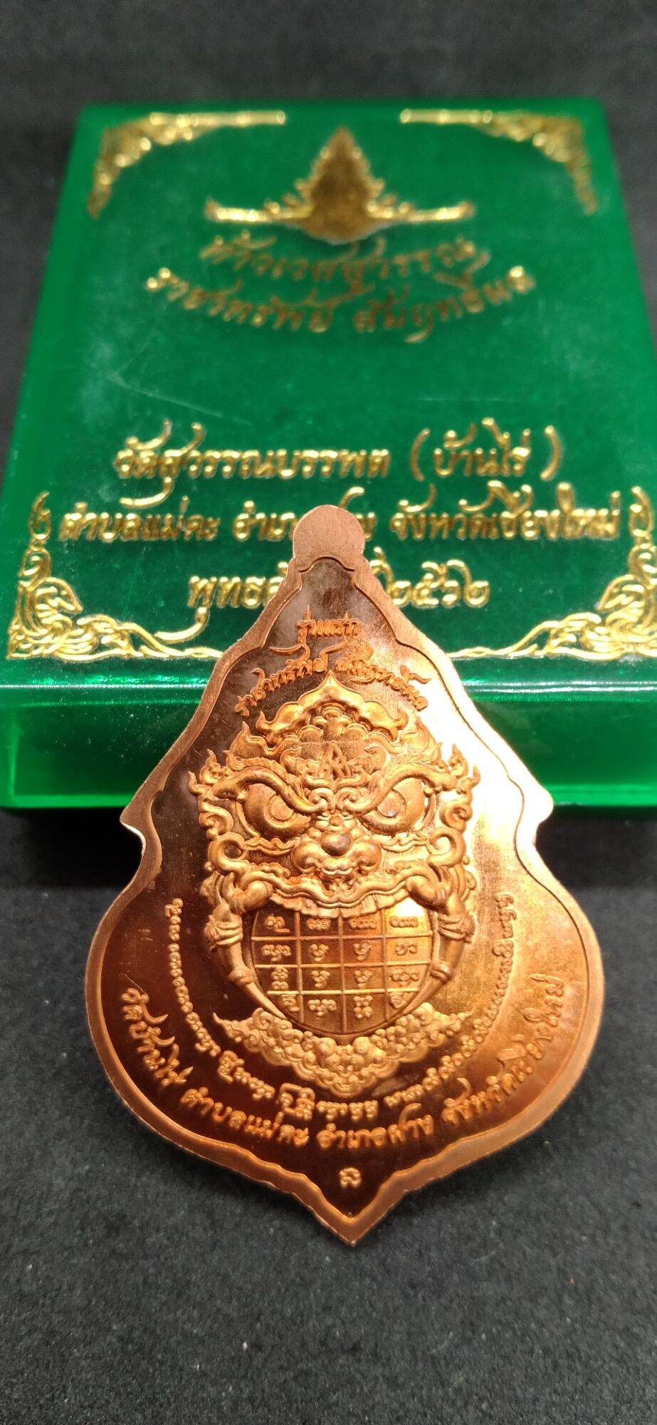 Thai Blessing Co Taowessuwan amulet for wealth with intricate design on copper metal and green decorative box