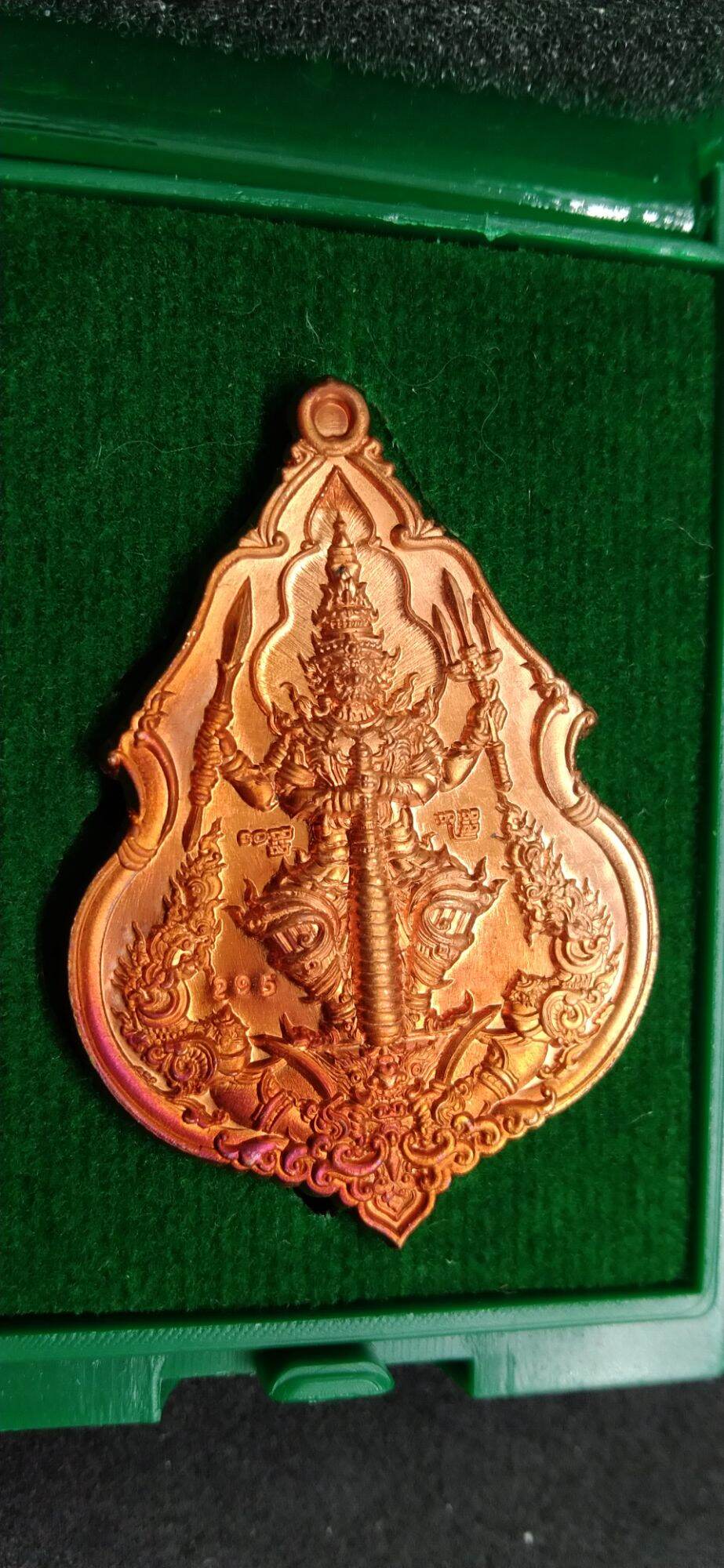 Thai Blessing Co Taowessuwan amulet for wealth in intricate gold design on green background