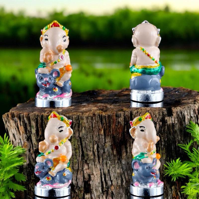Ganesha blessing amulet Thailand with intricate colorful details by Thai Blessing Co displayed on tree stump outdoors