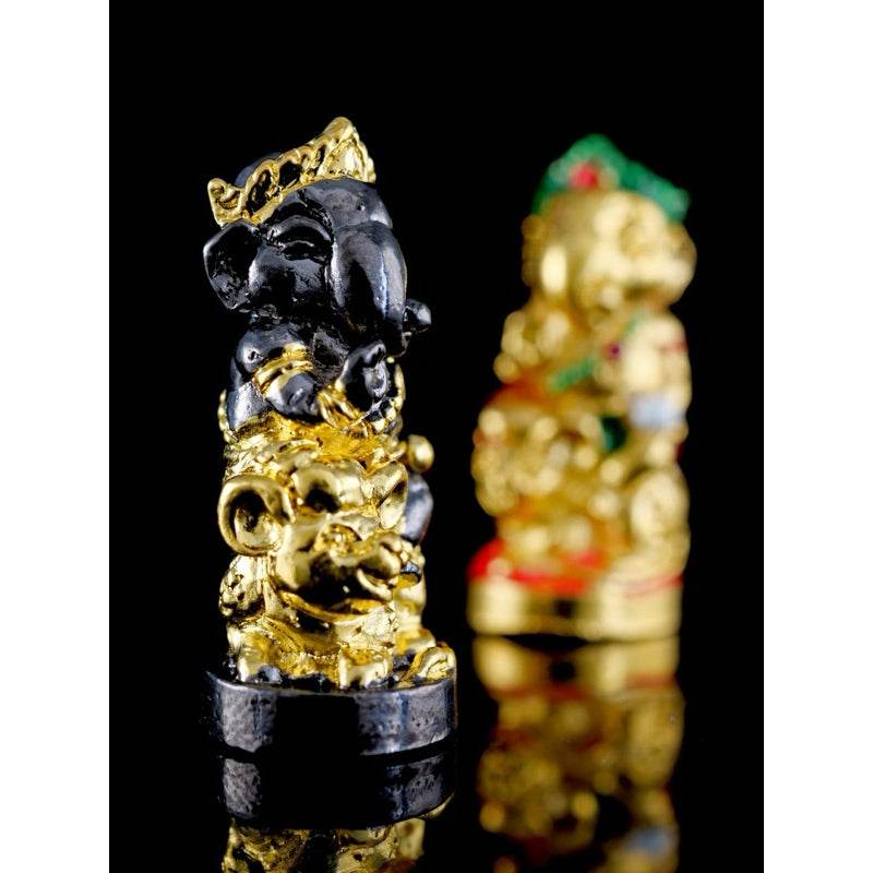 Black and gold Ganesha blessing amulet Thailand statue with intricate detailing on black background