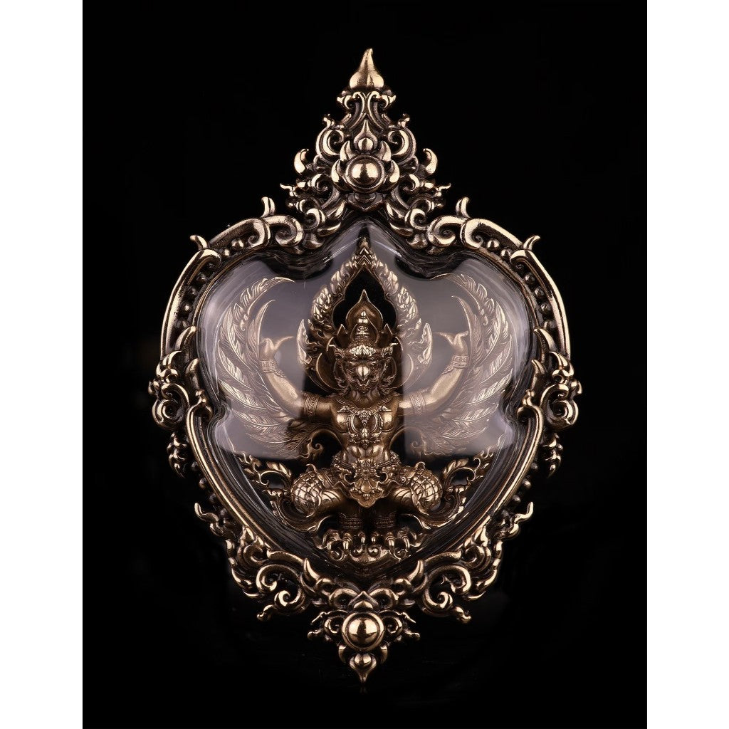 Intricate Garuda amulet for wealth and protection displayed in an ornate frame with detailed carvings