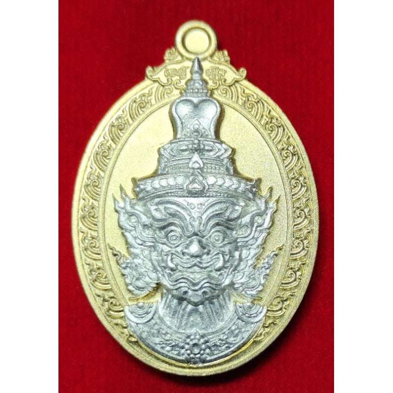 Thai Blessing Co Thaweesuwan wealth blessing amulet with intricate silver face design on gold oval pendant