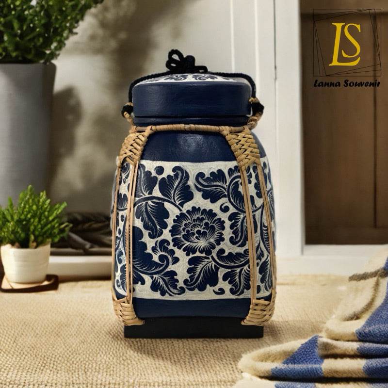 Lanna style bamboo storage box with navy floral pattern and woven handles on a beige surface