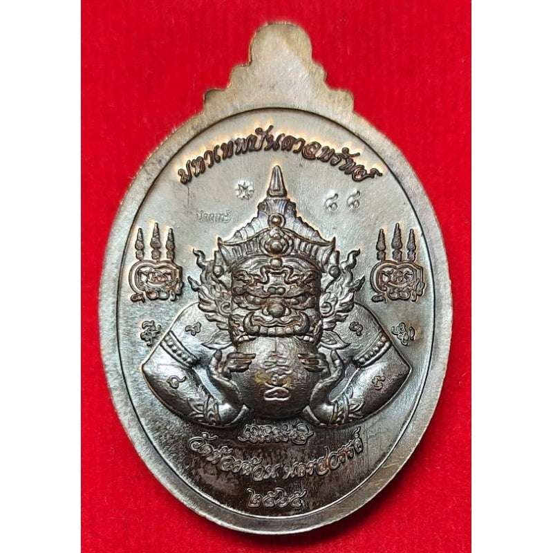 Thaweesuwan wealth blessing amulet with intricate traditional Thai design on red background