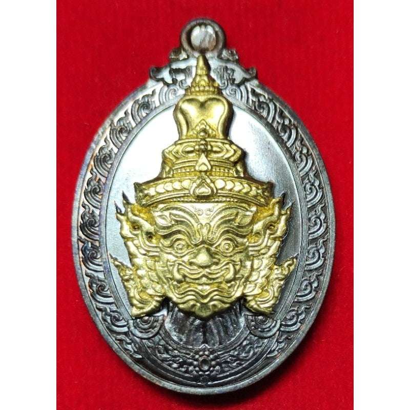 Thai Blessing Co Thaweesuwan wealth blessing amulet with detailed gold and silver design on red background