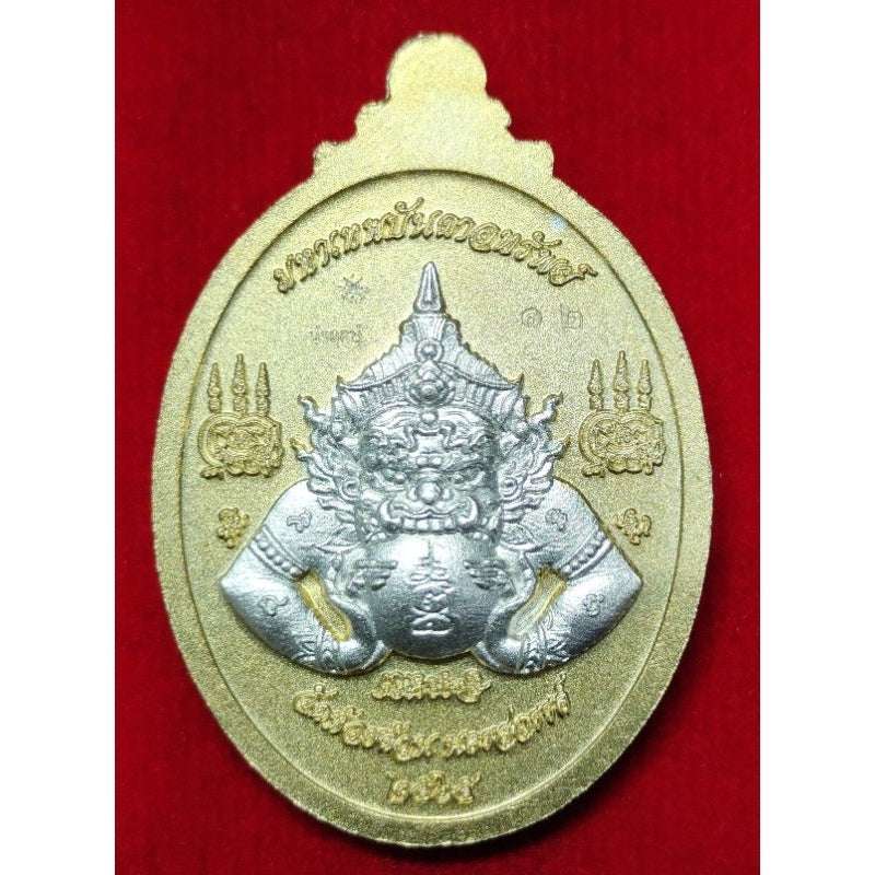 Thaweesuwan wealth blessing amulet with intricate silver deity design on gold oval base