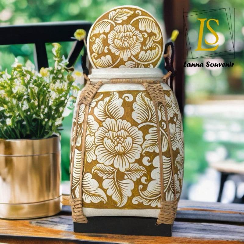 Lanna style bamboo storage box with white floral carvings placed on wooden table indoors